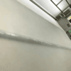 Industrial manufacturing line processing a large roll of white EVA interlayer film.
