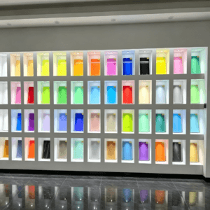 Showroom display wall featuring a diverse collection of colorful laminated glass samples using EVA Film for architectural design.