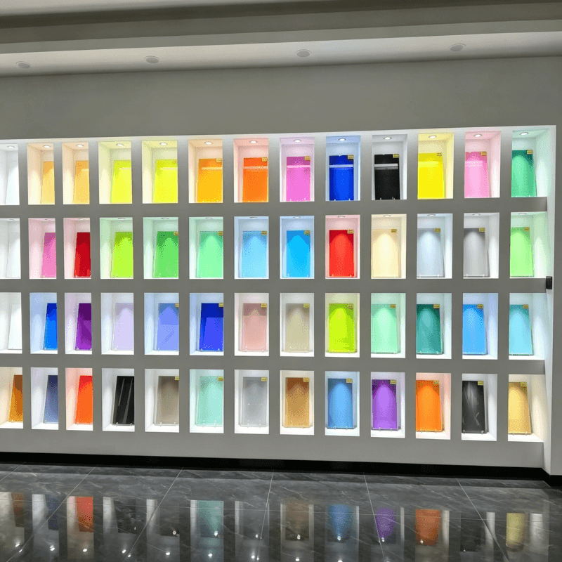Showroom display wall featuring a diverse collection of colorful laminated glass samples using EVA Film for architectural design.